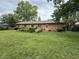 Expansive backyard with a well-maintained lawn, mature trees, and a patio at 645 Boulder Rd, Indianapolis, IN 46217