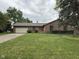 Charming brick ranch home with a lush green lawn, mature trees, and an attached two-car garage at 645 Boulder Rd, Indianapolis, IN 46217