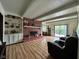 Open concept living room with a brick fireplace, built-in shelving, and access to the backyard at 645 Boulder Rd, Indianapolis, IN 46217
