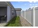 Side yard features gravel landscaping along a white fence separating green grass and house siding at 6738 Fox Club Ln, Brownsburg, IN 46112