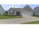 Well-maintained home with gray siding, a manicured lawn, and an attached two-car garage at 6738 Fox Club Ln, Brownsburg, IN 46112