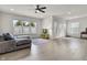 Open living room with large windows, ceiling fan, and comfortable gray seating arrangement at 6738 Fox Club Ln, Brownsburg, IN 46112