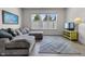 Cozy living room with large windows, plush gray sofa, and a bright yellow TV stand at 6738 Fox Club Ln, Brownsburg, IN 46112