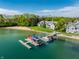 Stunning aerial view featuring a private beach, boat dock, and charming lakeside homes at 7849 Clearwater Cove Dr, Indianapolis, IN 46240
