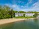 Overhead view of gray townhouse exteriors, adjacent sandy beach, and calming lake waters at 7849 Clearwater Cove Dr, Indianapolis, IN 46240