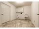 Practical laundry room featuring a utility sink, storage cabinets, and durable tile flooring at 7849 Clearwater Cove Dr, Indianapolis, IN 46240
