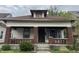 A charming, craftsman-style home featuring a cozy front porch with brick columns and steps at 811 N Oxford St, Indianapolis, IN 46201