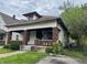 A charming, craftsman-style home featuring a cozy front porch with brick columns and steps at 811 N Oxford St, Indianapolis, IN 46201