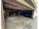 Spacious garage with open door to driveway, showing exposed wooden beams and concrete flooring at 811 N Oxford St, Indianapolis, IN 46201