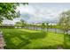 Lush backyard overlooking a pond with a fence, houses in the background, and large trees at 8269 S Midnight Dr, Pendleton, IN 46064