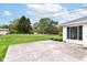View of the backyard, featuring a lawn, shed, mature trees, and a concrete patio at 8606 N Washington Blvd, Indianapolis, IN 46240