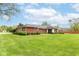 Long shot of the backyard and the home, featuring a large lawn and manicured shrubs at 8606 N Washington Blvd, Indianapolis, IN 46240