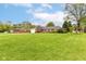 Wide shot of the front yard and home, with an expansive lawn and mature trees at 8606 N Washington Blvd, Indianapolis, IN 46240