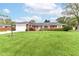 Charming single story red brick home with an attached garage and a lush green front yard at 8606 N Washington Blvd, Indianapolis, IN 46240