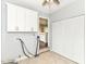Laundry room with tile flooring, grey walls, overhead cabinets, and close access to the kitchen at 8606 N Washington Blvd, Indianapolis, IN 46240