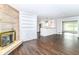 Open-concept living space with a stone fireplace, built-in shelving, and a view into the kitchen at 8606 N Washington Blvd, Indianapolis, IN 46240