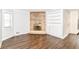 Bright living area featuring dark wood floors, a stone fireplace, and built-in shelving at 8606 N Washington Blvd, Indianapolis, IN 46240