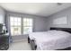 Bright bedroom features two windows, grey walls, carpet flooring and a queen bed at 8709 Orchard Grove Ln, Camby, IN 46113