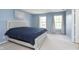 Main bedroom with carpet, blue accent wall, natural light from the windows, and a queen bed at 8709 Orchard Grove Ln, Camby, IN 46113