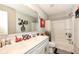 Well-lit bathroom with double sinks, framed mirror, and shower with white tile surround at 8811 Dorill Creek Ln, Indianapolis, IN 46259