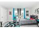 Bright bedroom featuring a gray bed, colorful rug, and decor under a window with blue curtains at 8811 Dorill Creek Ln, Indianapolis, IN 46259