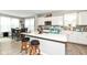 Bright kitchen boasts a large island with stool seating, modern white cabinetry and stainless steel appliances at 8811 Dorill Creek Ln, Indianapolis, IN 46259