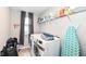 Bright laundry room features modern washer and dryer, and shelving for storage at 8811 Dorill Creek Ln, Indianapolis, IN 46259