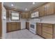 Well-lit kitchen featuring wooden cabinets, white appliances, tile flooring, and a bright, clean space at 948 Peppermill Run, Greenwood, IN 46143
