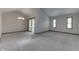 Bright, spacious living room featuring neutral carpet, vaulted ceilings, and sliding glass doors to the outside at 948 Peppermill Run, Greenwood, IN 46143