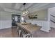Bright dining room with a farmhouse table set, wainscoting, black hutch and a view into other rooms at 1015 Supernova Dr, Franklin, IN 46131