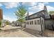 View of a row of townhouses with a gray exterior, garage, chimney, balcony, and stone landscaping under a blue sky at 1030 Stratford Hall # 17-3, Indianapolis, IN 46260