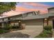 Charming townhome featuring a brick facade, attached garage, and lovely landscaping at 1030 Stratford Hall # 17-3, Indianapolis, IN 46260