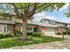 Charming townhome featuring a brick facade, attached garage, and mature shade tree at 1030 Stratford Hall # 17-3, Indianapolis, IN 46260