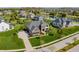 Aerial view of a brick home with manicured lawn, landscaping, and a neighborhood lake at 10473 Ranford Blvd, Fishers, IN 46040
