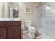 Bathroom showcasing a dark wood vanity, toilet, and glass-enclosed shower with tiled walls at 10473 Ranford Blvd, Fishers, IN 46040