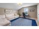 Spacious bonus room with comfortable sofa, desk, and bright blue rug at 10473 Ranford Blvd, Fishers, IN 46040