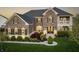 Charming two-story brick home featuring lush landscaping at dusk at 10473 Ranford Blvd, Fishers, IN 46040
