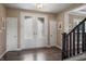 Inviting foyer featuring wood floors, a glass front door, and adjacent staircase at 10473 Ranford Blvd, Fishers, IN 46040