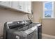 Well-lit laundry room showcasing modern, stainless steel washer and dryer with white cabinets for storage at 10473 Ranford Blvd, Fishers, IN 46040