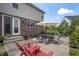 Cozy backyard patio with red Adirondack chairs, a dining table, and an umbrella at 10473 Ranford Blvd, Fishers, IN 46040
