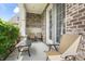 Covered front patio with brick and stone accents offering relaxing outdoor seating space at 10473 Ranford Blvd, Fishers, IN 46040