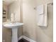 Elegant powder room featuring a pedestal sink, a decorative mirror, and neutral color scheme at 10473 Ranford Blvd, Fishers, IN 46040
