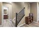 Hallway view of carpeted staircase with dark wood banister and trim, adjacent to furnished basement at 10473 Ranford Blvd, Fishers, IN 46040