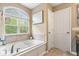 Bright bathroom with a large soaking tub, natural light, and neutral-colored walls at 10531 Cleary Trce, Fishers, IN 46040