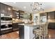 A stylish kitchen boasts stainless appliances, granite counters, an island with seating and dark cabinets at 10531 Cleary Trce, Fishers, IN 46040