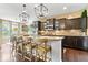 Modern kitchen boasts a spacious island with seating, pendant lighting, and dark cabinetry and hardwood floors at 10531 Cleary Trce, Fishers, IN 46040