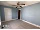 Blue bedroom with a fan, carpeted floors, and natural light from a window at 113 1St St, Shelbyville, IN 46176