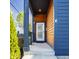 Close-up of the entrance showcasing blue siding, a wooden door frame, and a well-lit, modern welcome at 1226 Cottage Ave, Indianapolis, IN 46203