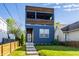 Inviting three-story home featuring a modern design, blue siding, a cozy balcony, and well-maintained lawn at 1226 Cottage Ave, Indianapolis, IN 46203