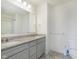 Modern bathroom features a double-sink vanity with granite countertops, tiled floors and ample space at 13204 Caterwood Cir, Fishers, IN 46037